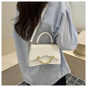 Stylish white top-handle shoulder bag with unique curved design and chic gold chain detail.