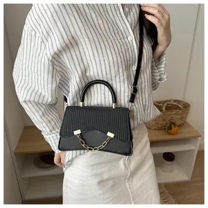 Elegant black shoulder crossbody handbag with top handle and gold chain detail for women detail.