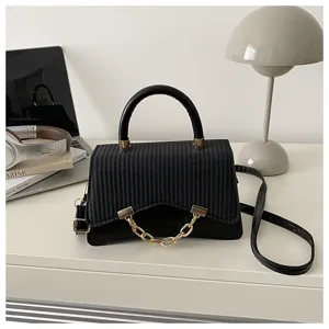 Detailed view of the stylish black structured women crossbody handbag with elegant golden chain accent.