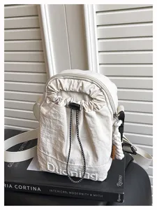 Detail view of a mini casual crossbody phone bag in off-white fabric with drawstring closure.