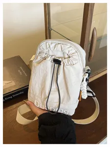 Detail view of the casual minimalist beige crossbody phone bag with drawstring and embroidery.