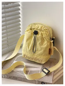 Detailed view of the casual yellow nylon crossbody phone bag with stylish drawstring closure.
