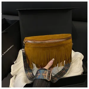 Detailed view of brown suede fringe crossbody bag featuring a patterned ethnic strap.