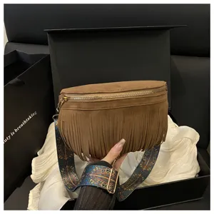 Brown suede fringe crossbody bag detail view, retro style waist pack with patterned strap.