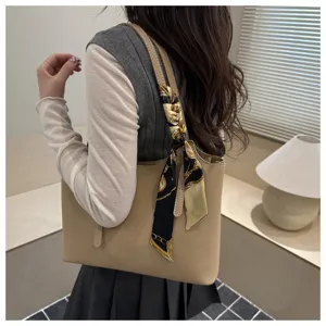 Dettaglio della borsa a shopper minimalista da donna elegante con foulard di seta chic.