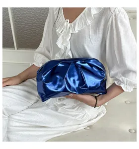 Vue détaillée d'une pochette froncée bleu métallisé, sac à main brillant pour soirée.
