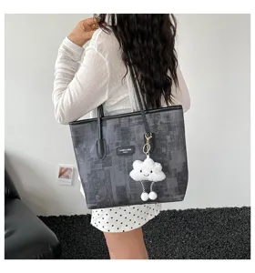 Vue détaillée du grand sac cabas avec pendentif nuage mignon sur le dos du modèle.