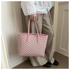 Pink monogram tote bag detail shot showing large capacity design and elegant pink handles.