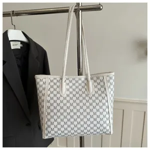Detail of letter print tote bag, showing monogram pattern and spacious interior for commute.