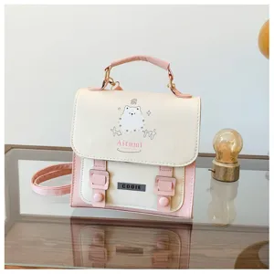 Dettaglio ravvicinato di mini zaino rosa e crema con stampa carina e doppie fibbie.