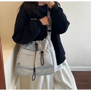 Casual drawstring shoulder bag with front pockets, minimalist slouchy crossbody tote for autumn.