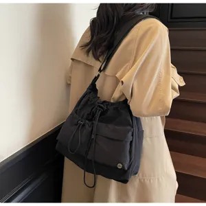Minimalist black drawstring shoulder bag, casual versatile crossbody tote for daily wear.