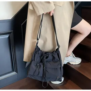 Minimalist nylon drawstring shoulder bag, casual slouchy crossbody tote for daily fashion wear.