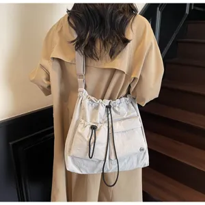 Detailed showcase of the stylish light grey nylon drawstring shoulder crossbody bag.