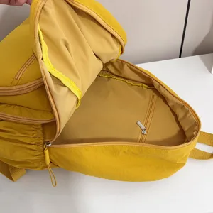 Yellow casual backpack interior detail view, large capacity daily school bag with secure zipper pockets.