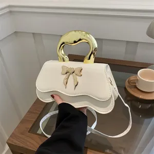 Élégant sac à main blanc avec nœud doré, sac bandoulière élégant pour la mode des femmes.