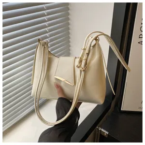 Detail shot of stylish white shoulder baguette bag, featuring elegant metallic buckle and dual straps.