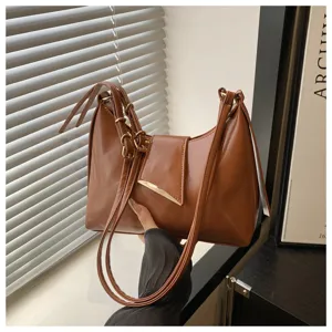 Brown leather baguette shoulder bag detail view, stylish underarm purse with metal buckle.