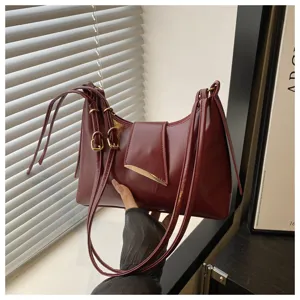 Burgundy shoulder bag detail, elegant underarm bag with metallic buckle and multi-straps.