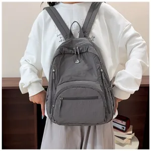 Detail view of a gray casual nylon backpack with multiple zipper pockets for daily use.