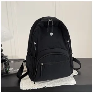 Detailed view of black nylon minimalist casual backpack featuring multiple secure zipper compartments.