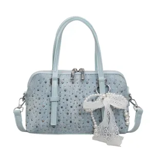 Light blue denim handbag with metal studs and white lace pearl bow, chic crossbody bag.