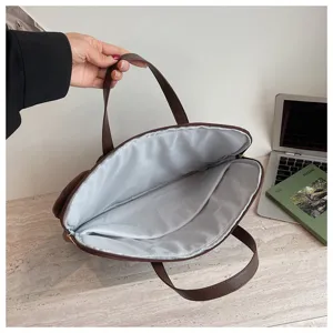 Borsa per laptop da lavoro scompartita con interno in pile morbido e manici in pelle.