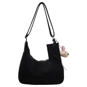 Black suede shoulder bag for women, large capacity casual hobo tote with cute plush charm.