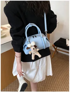 Vista detallada del bolso tipo almohada azul claro con bonito llavero de perro, elegante bolso cruzado.