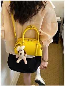 Elegante bolso de hombro tipo almohada de cuero PU amarillo con lindo colgante de perro.