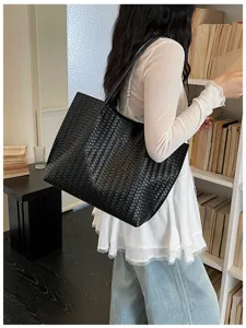 Vue détaillée du sac cabas en cuir tressé noir, texture haut de gamme et grande capacité.