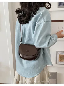 Vintage brown saddle shoulder bag for women, elegant faux leather crossbody mini bag detail view.