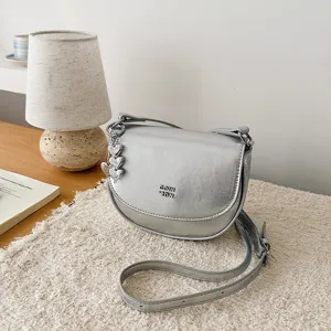 Stylish silver mini shoulder bag for women, trendy metallic crossbody bag with cute charm.