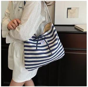 Detail view of Korean style blue and white striped canvas shoulder bag with bow string design.