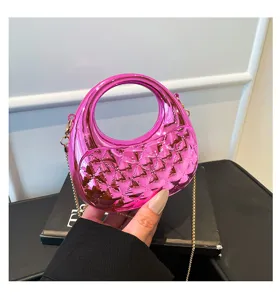Close-up detail of a pink translucent acrylic mini handbag with chic diamond quilting and chain.