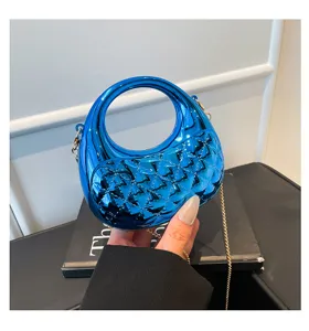 Glossy blue acrylic handbag featuring a chic quilted texture, round top handle and metal chain.