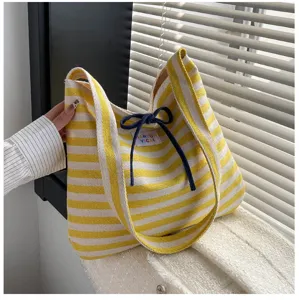 Yellow white striped canvas shoulder bag detail, cute bow tie decoration, daily commute.