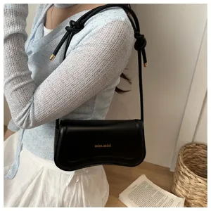 Elegant black shoulder underarm bag for women, chic minimalist design with knot strap details.