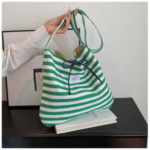 Green and white striped canvas shoulder bag detail view, casual commute tote style.