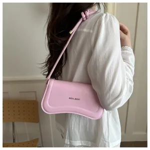 Detailed shot of a pink leather shoulder bag worn by a model, showcasing its chic baguette design.