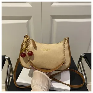 Chic beige shoulder bag with brown trim and cute cherry charm, stylish women crossbody bag.