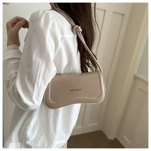 Chic minimalist underarm shoulder bag for women, elegant curved design with knotted strap.