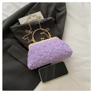 Close-up detail of a purple floral evening clutch bag with gold kiss-lock frame and chain.