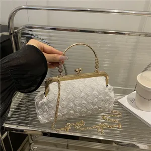 Elegant white floral evening bag with gold metal kiss-lock frame and chain strap.
