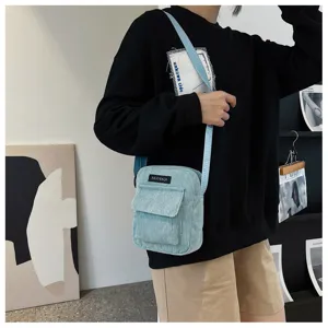 Light blue corduroy crossbody bag detail shot, showing textured front pocket and shoulder strap.