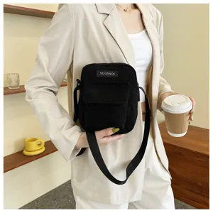 Black corduroy cross-body bag detail, casual daily shoulder purse featuring an adjustable strap.
