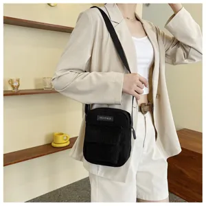 Detailed view of a black corduroy crossbody bag, simple Korean style shoulder bag for women.