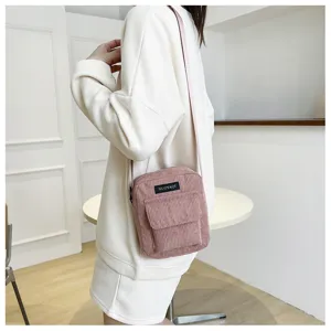 Pink corduroy crossbody bag for women, casual minimalist shoulder bag with front pocket.