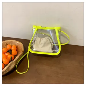 Clear jelly crossbody bag with neon yellow trim and a beige drawstring inner pouch detail.