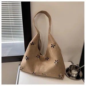 Detailed view of women's casual suede tote bag featuring elegant hollow flower cutout patterns.
